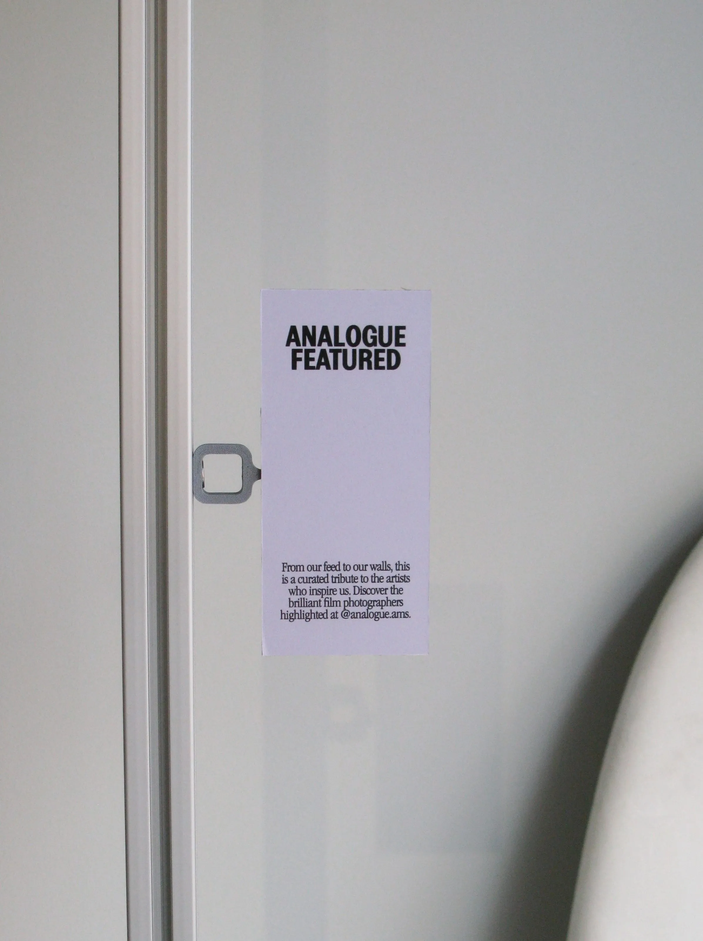 Print gallery card held by a 3D printed clip on an extrusion frame, Analogue store Zeedijk