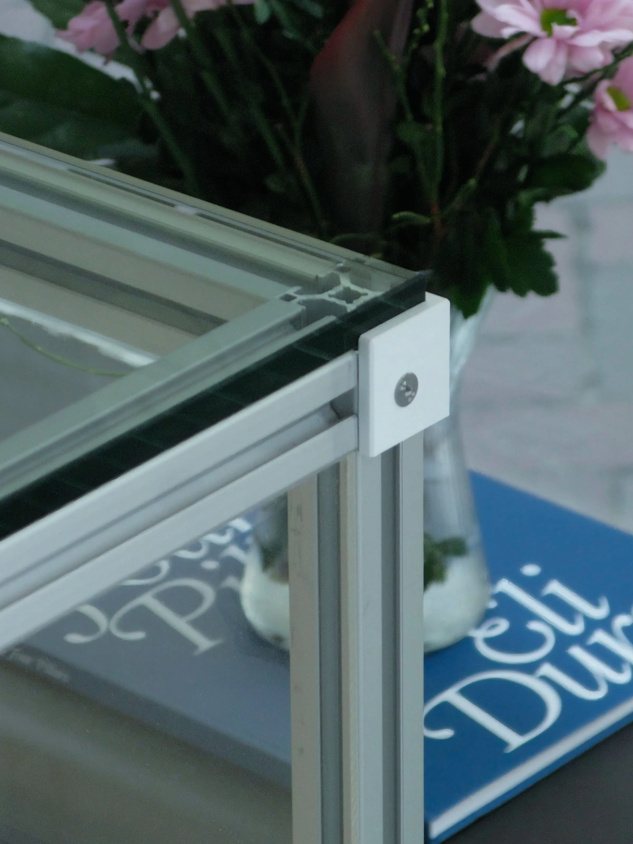 Corner of a vitrine with glass top and printed connector, Analogue store Zeedijk