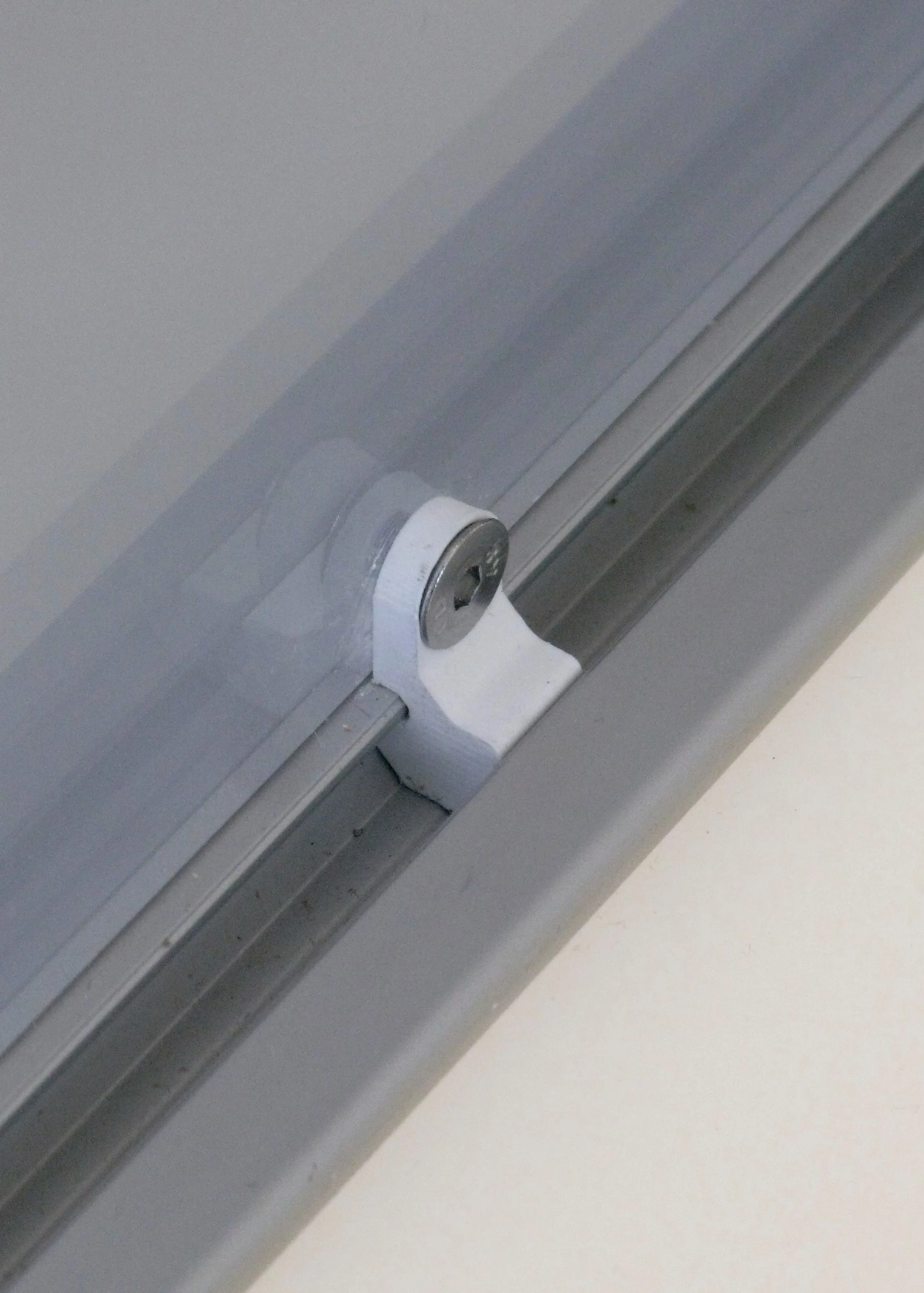 3D printed clip holding a glass panel in an aluminium extrusion, Analogue store Zeedijk