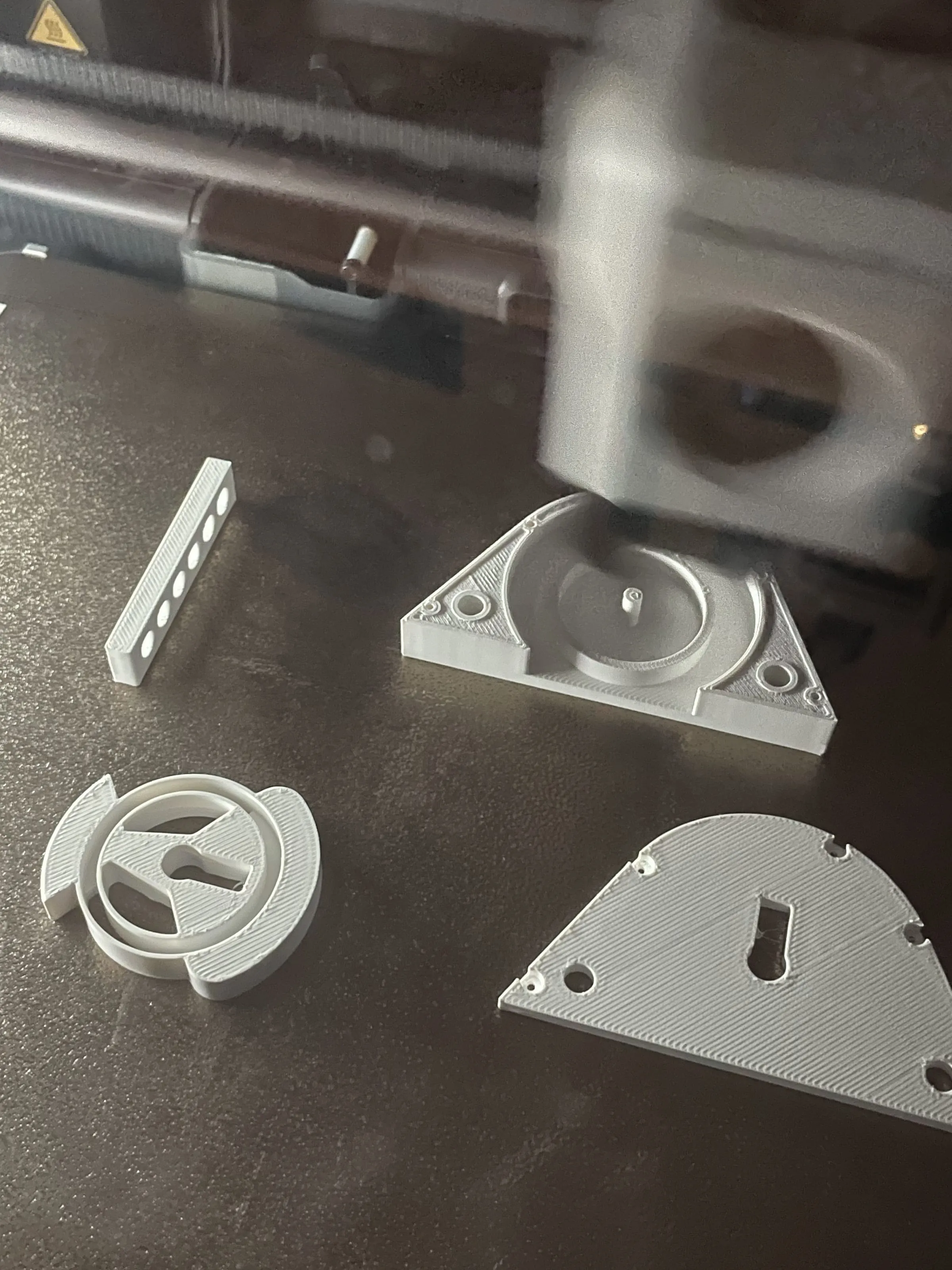 3D printed brackets and caps laid out on a table, Analogue store Zeedijk