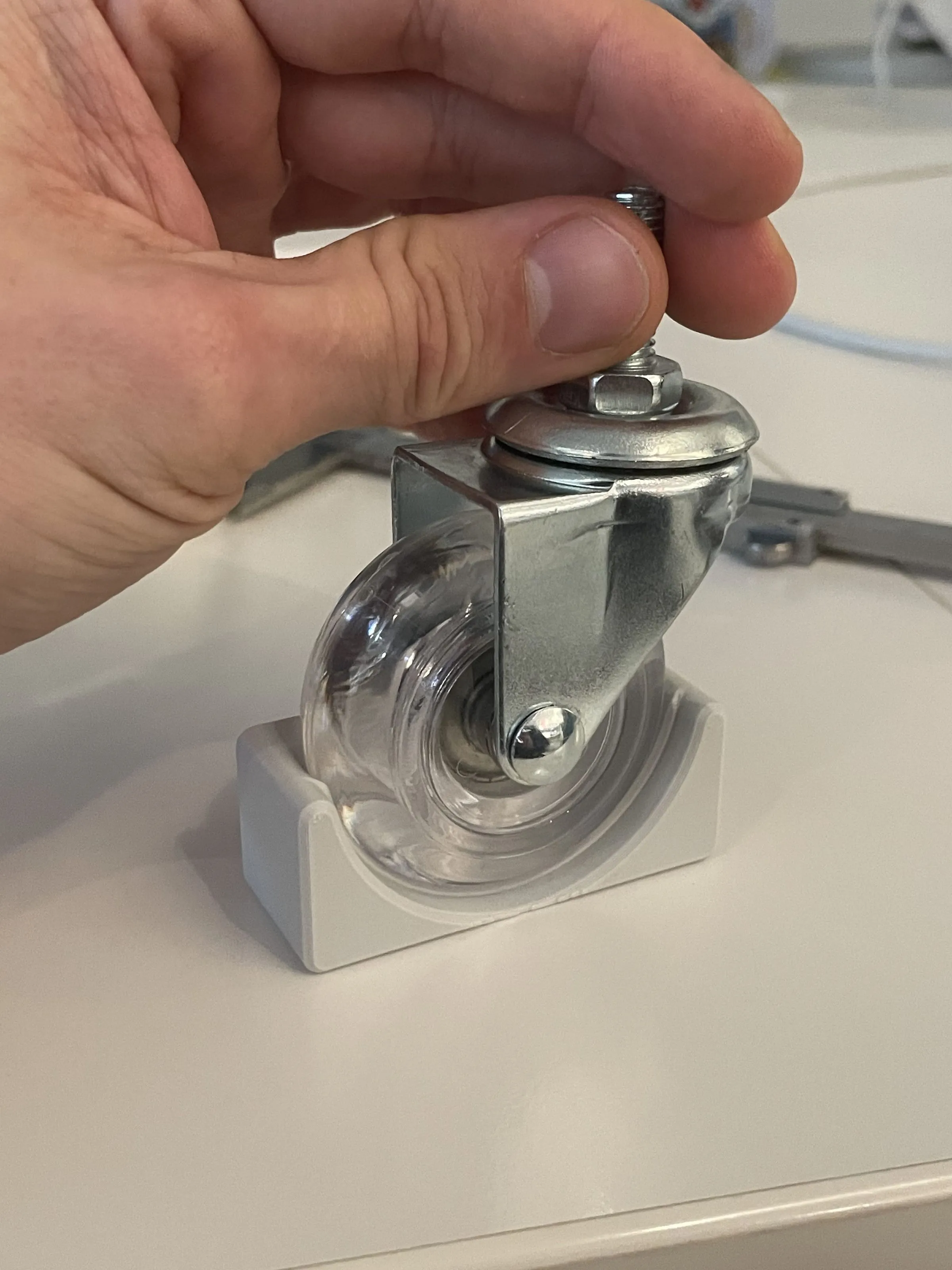 Hand fitting a caster wheel into a 3D printed mount, Analogue store Zeedijk